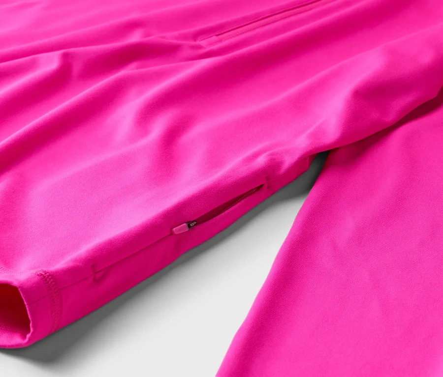 Detail ružovej bundy s vreckom na zips na rukáve.