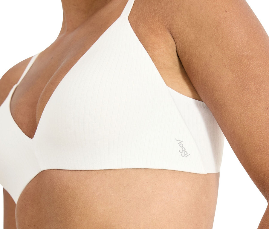 Žena má na sebe bielu trojuholníkovú podprsenku s tenkými ramienkami a rebrovanou štruktúrou.