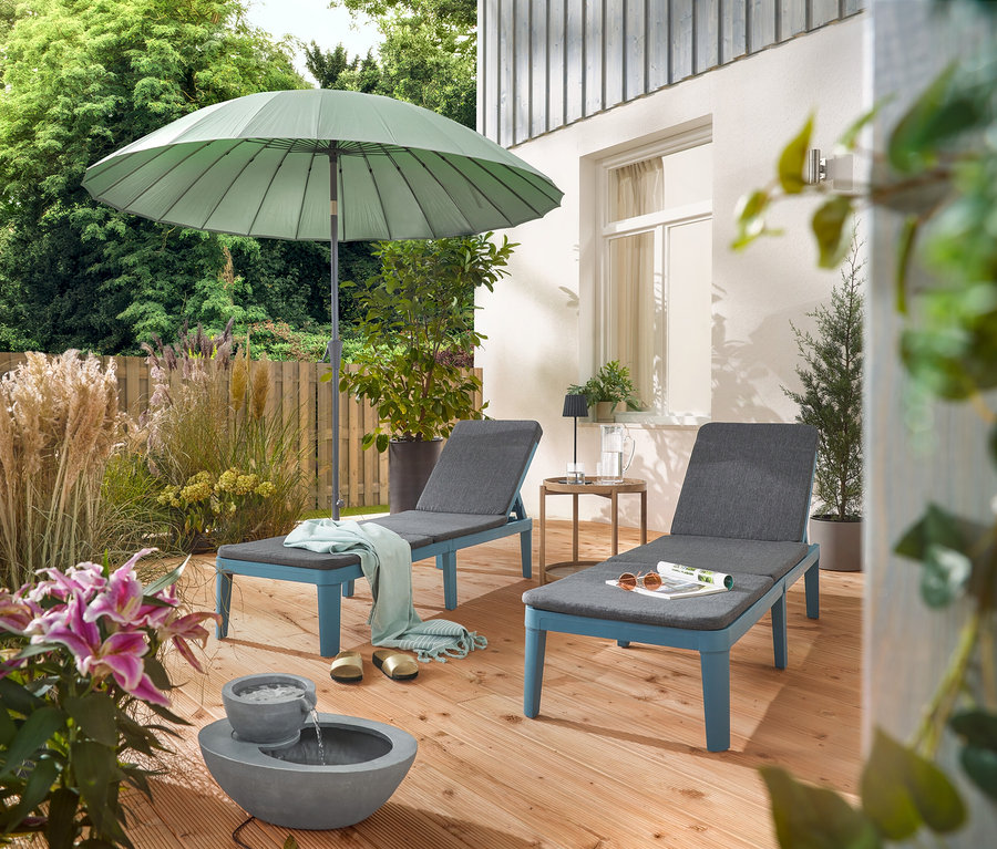 Na terase sú dve ležadlá pod svetlosivým slnečníkom Leco Shanghai a vedľa solárnej záhradnej fontány.