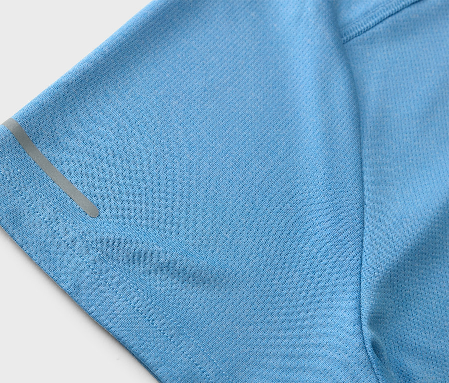 Detailný záber na svetlomodré športové tričko s reflexným pásikom na rukáve.