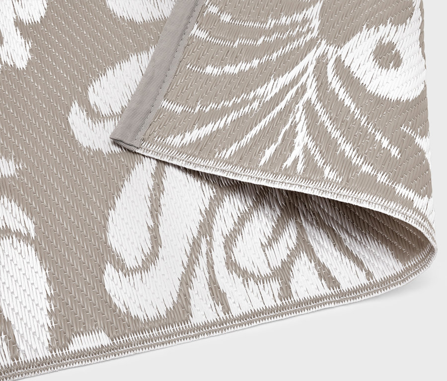 Detailný záber vonkajšieho koberca so sivo-bielym vzorom.