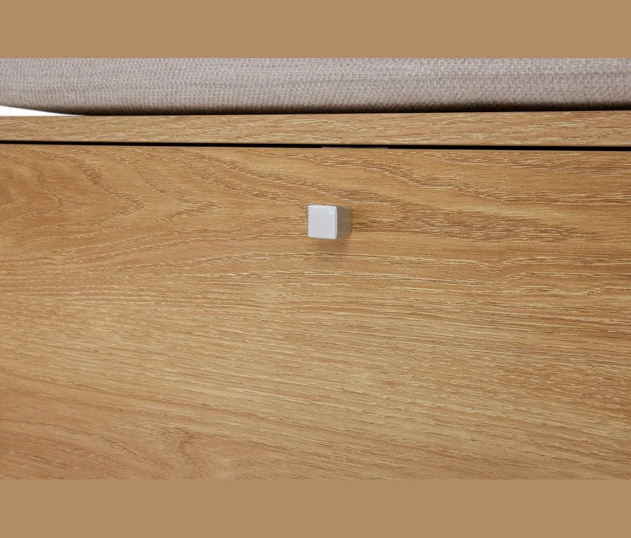 Detailný záber na svetlohnedú drevenú komodu so zásuvkou a striebornou štvorcovou úchytkou.