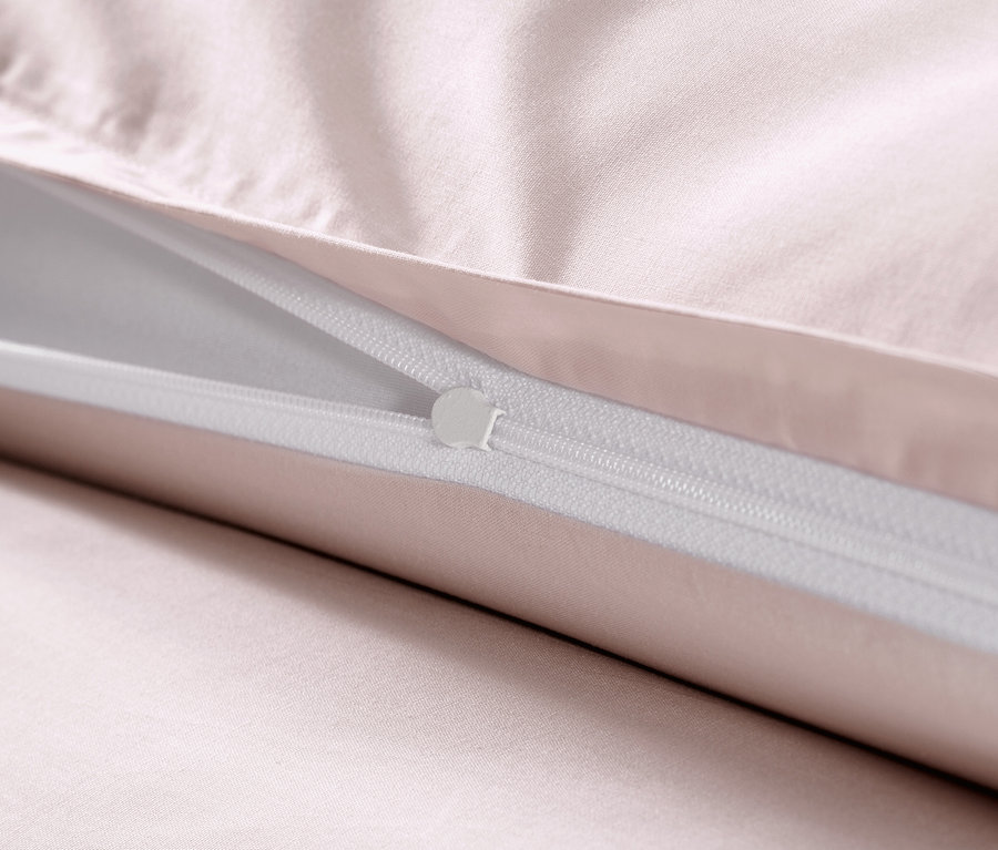 Detail ružových obliečok z bavlneného saténu so zipsom.