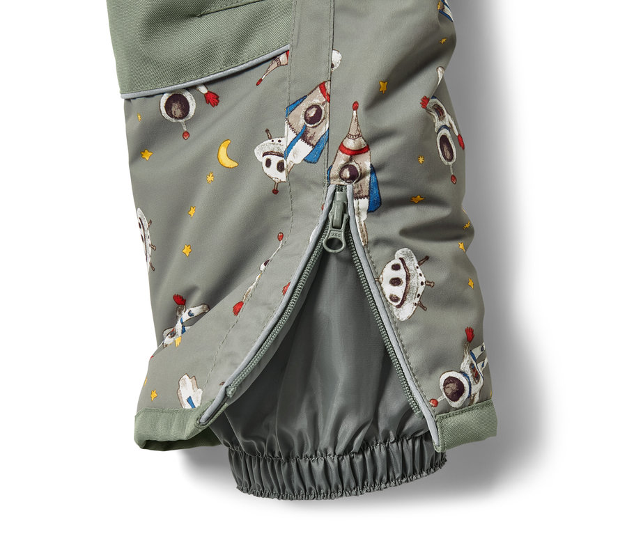 Detail detskej zimnej súpravy s potlačou vesmírnych lodí a rozopnutým zipsom.