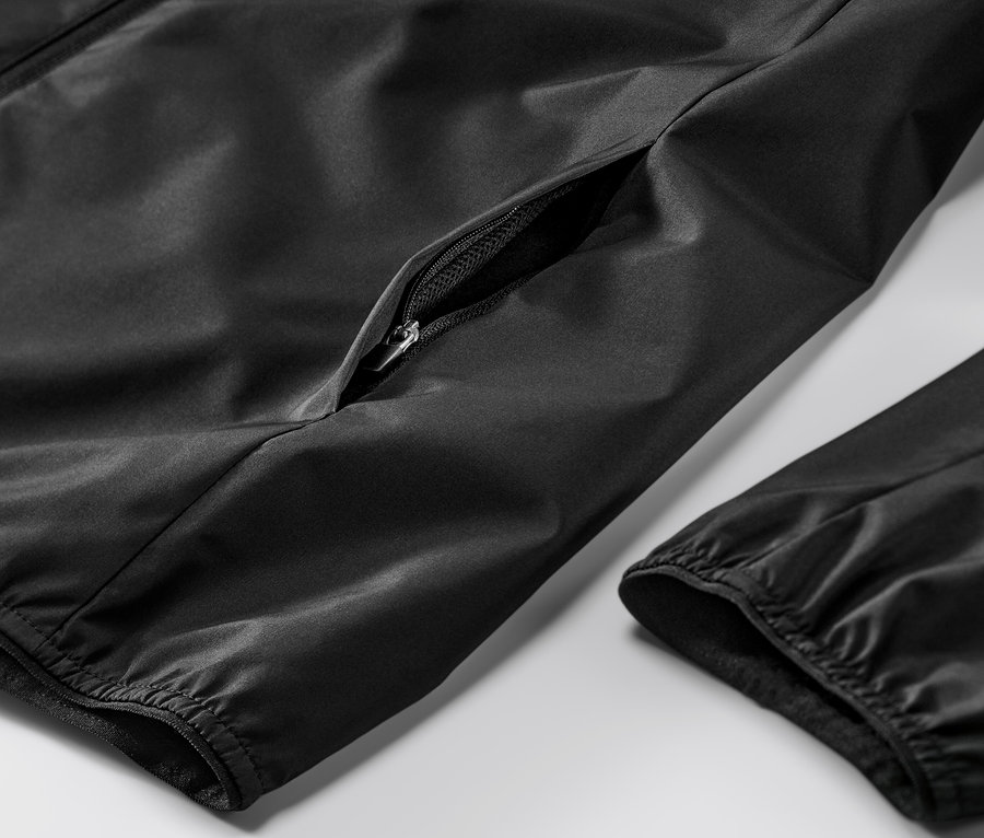 Detail čiernej vetruvzdornej bežeckej bundy s vreckom na zips.