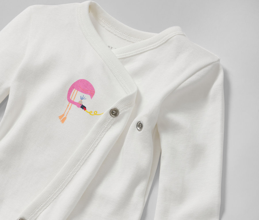 Detail bieleho body pre bábätká s možnosťou prispôsobenia veľkosti s výšivkou plameniaka.