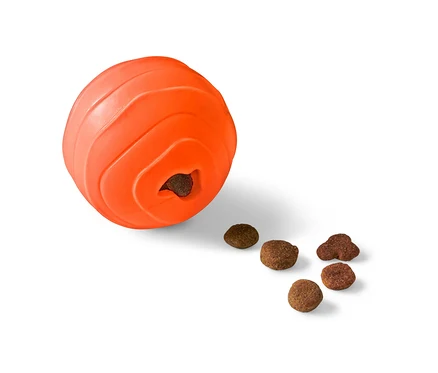 Oranžová loptička s maškrtami pre psy s otvorom, z ktorého vypadávajú granule.