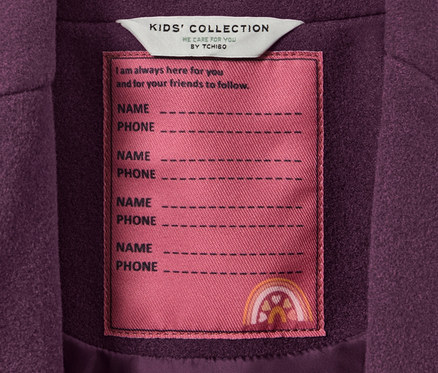 Detail detského kabáta s visačkou KIDS' COLLECTION s miestom na meno a telefón.