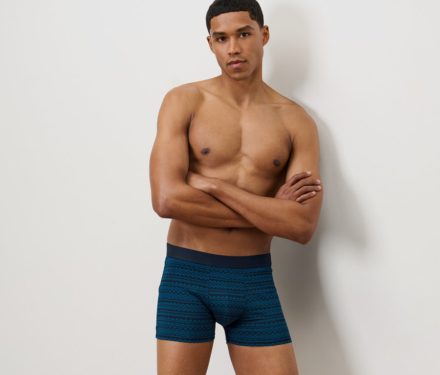 Muž pózuje s rukami prekríženými na hrudi a má na sebe boxerky, 2 ks, nórsky vzor.