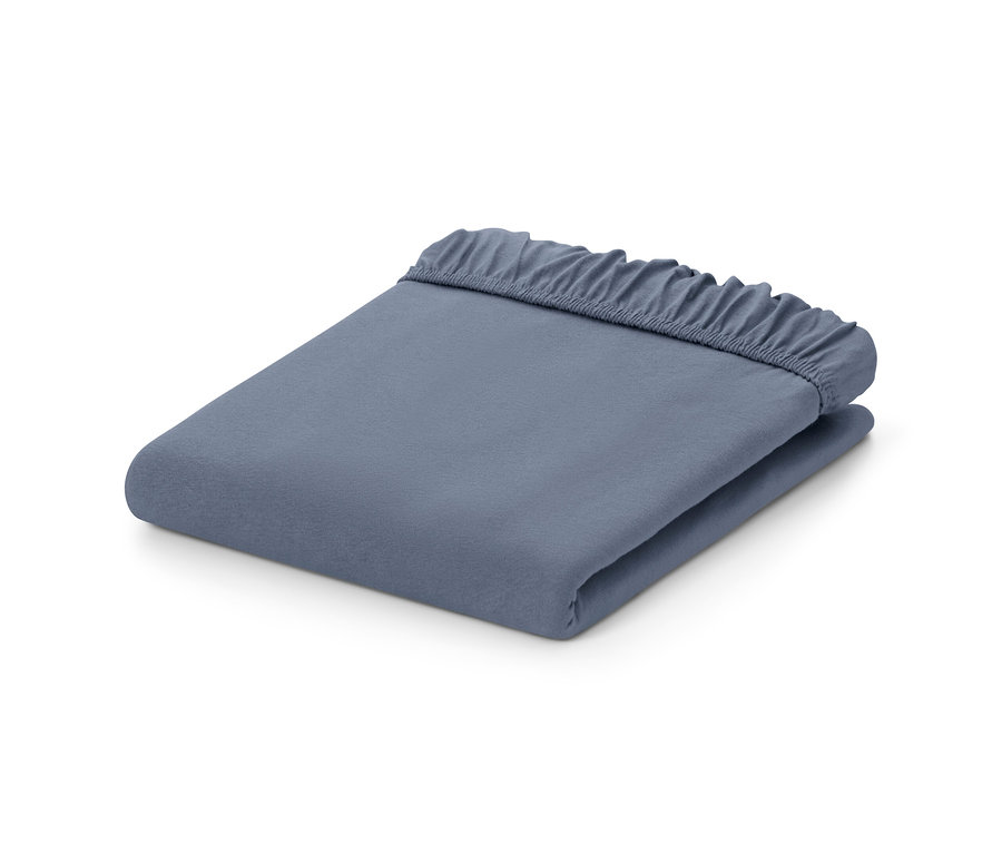 Zložená modrá džersejová plachta s gumou.