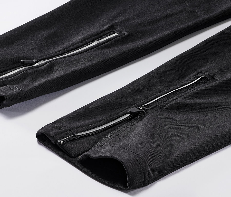 Detail cyklistických nohavíc so zipsami na nohaviciach.