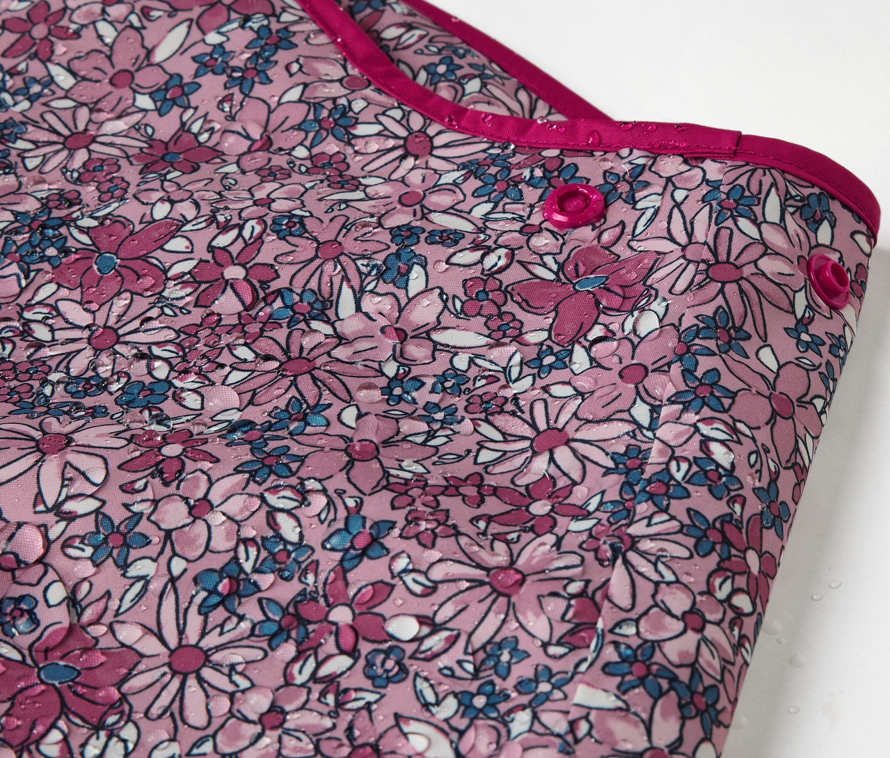 Detail detských termo nohavíc do dažďa s kvetinovou potlačou.