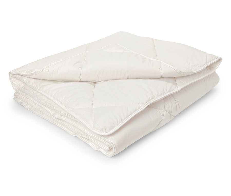 Zložená biela prešívaná prikrývka.