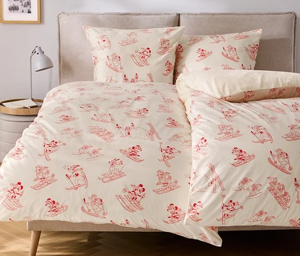 Posteľná bielizeň s červenými obrázkami Mickeyho Mousa na lyžiach.