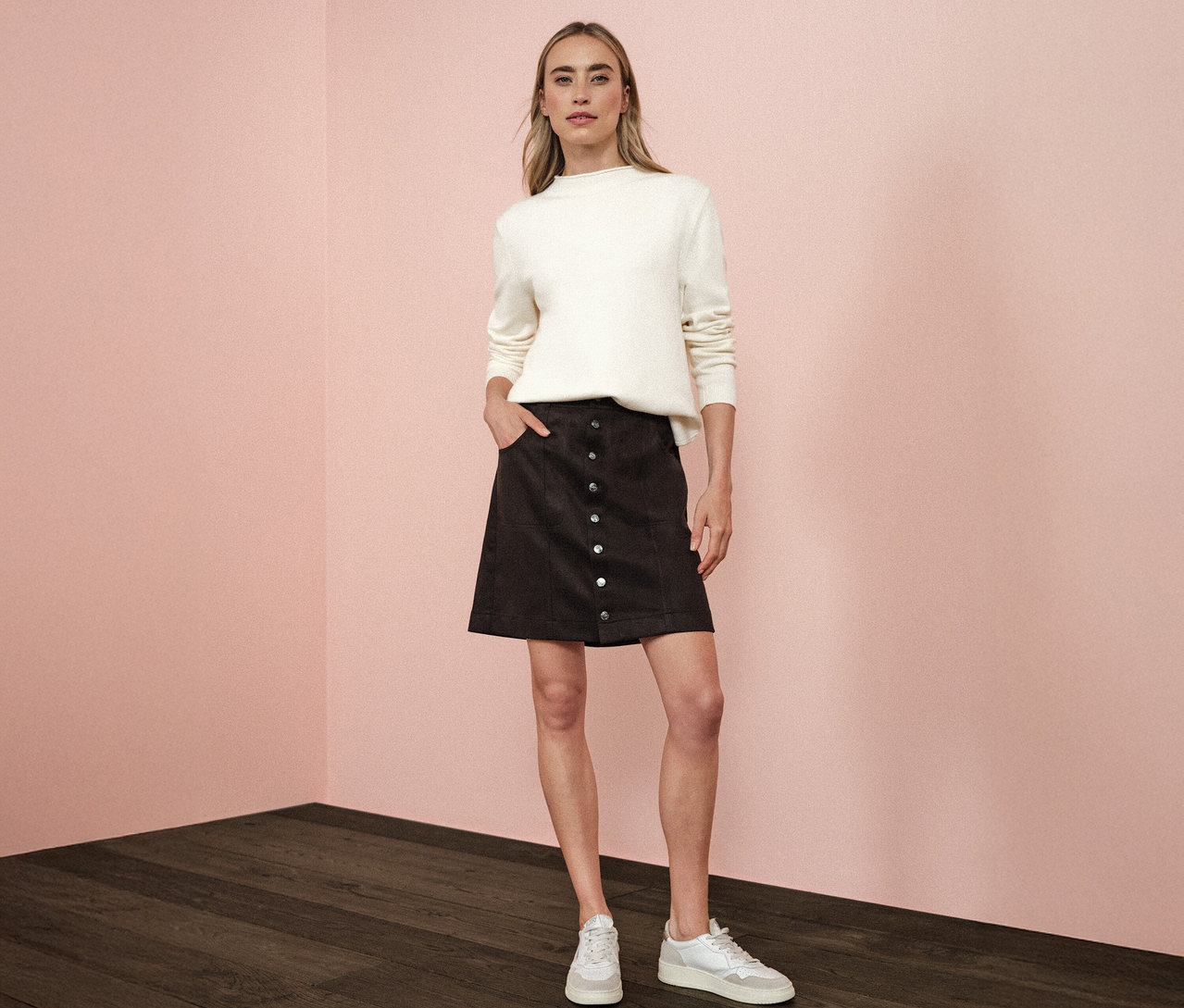 Žena stojí s rukou vo vrecku hnedej velúrovej sukne Street One.