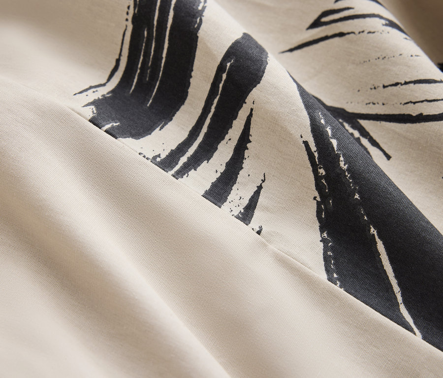 Detail krémovej látky s tmavomodrou abstraktnou potlačou.