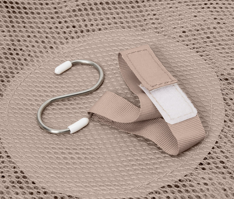 Hák a popruh ležia na béžovej úložnej sieťke.