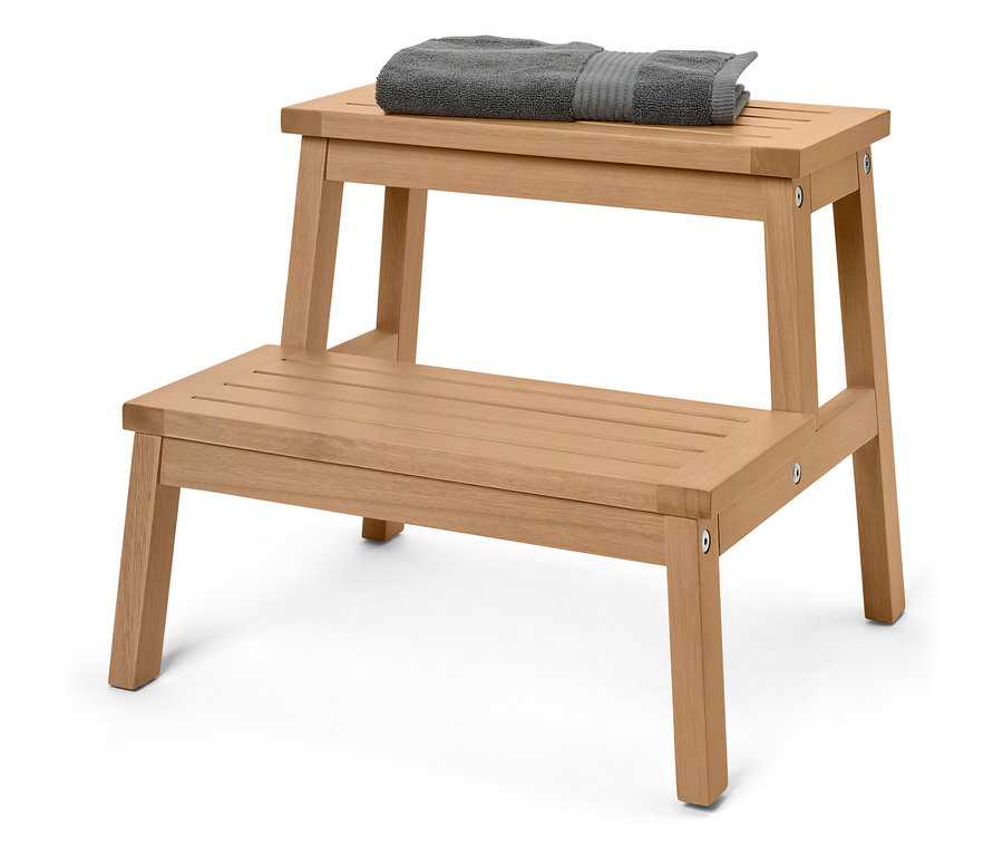 Drevená stolička s dvoma schodíkmi, na hornom schodíku leží sivý uterák.