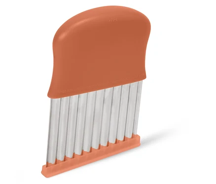 Detailný záber na oranžový krájač zeleniny so zvlnenými čepeľami.