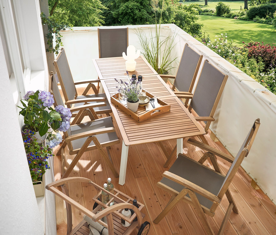 Na balkóne sa nachádza úzky rozkladací záhradný stôl »Liska«, krémová balkónová clona a ochrana proti vetru, barový vozík s odnímateľnou podnosom a LED vonkajšia dobíjacia stolná lampa, kaktus.