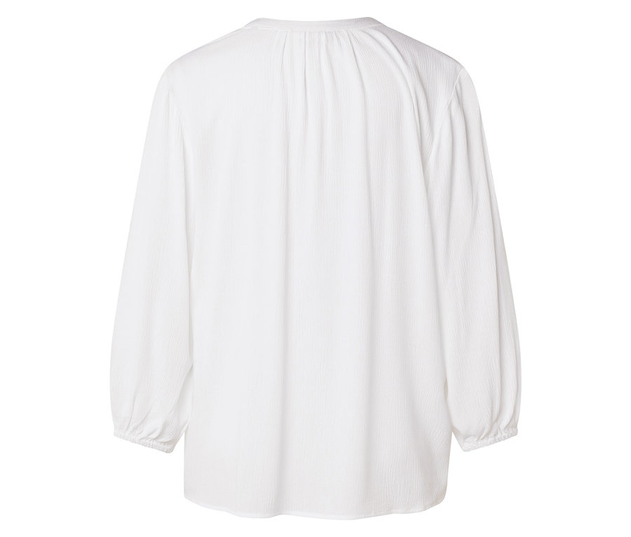 Pohľad zozadu na bielu blúzku s dlhým rukávom.