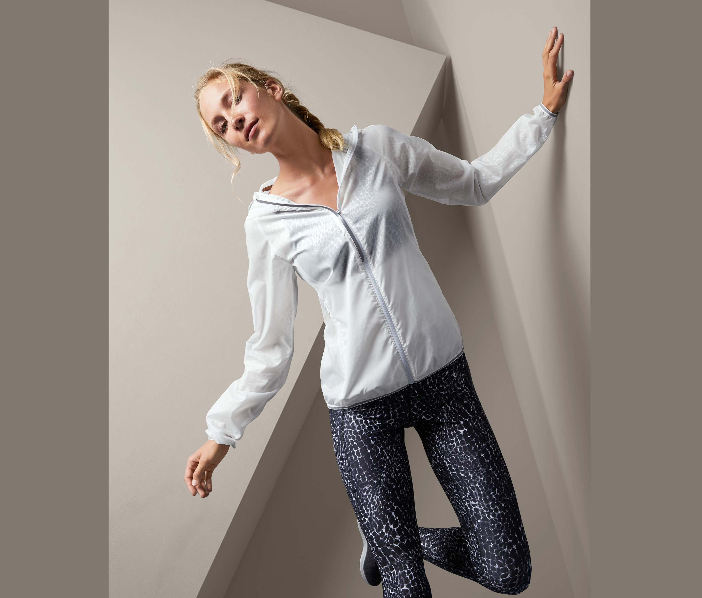 Žena pózuje v ľahkej bežeckej bundě.