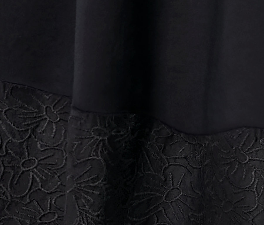 Detail tkaných šiat s výšivkou.