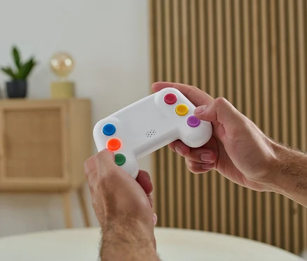 Muž drží v rukách elektronický precvičovateľ pamäti s farebnými tlačidlami.