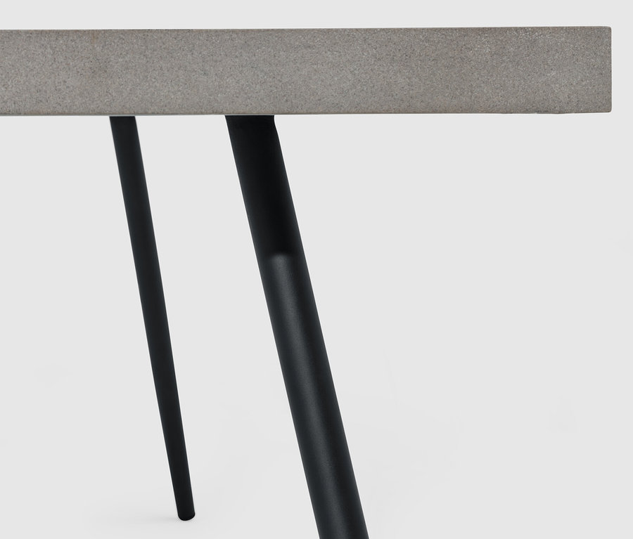 Detail konferenčného stolíka s doskou stola z polycementu a čiernymi nohami.