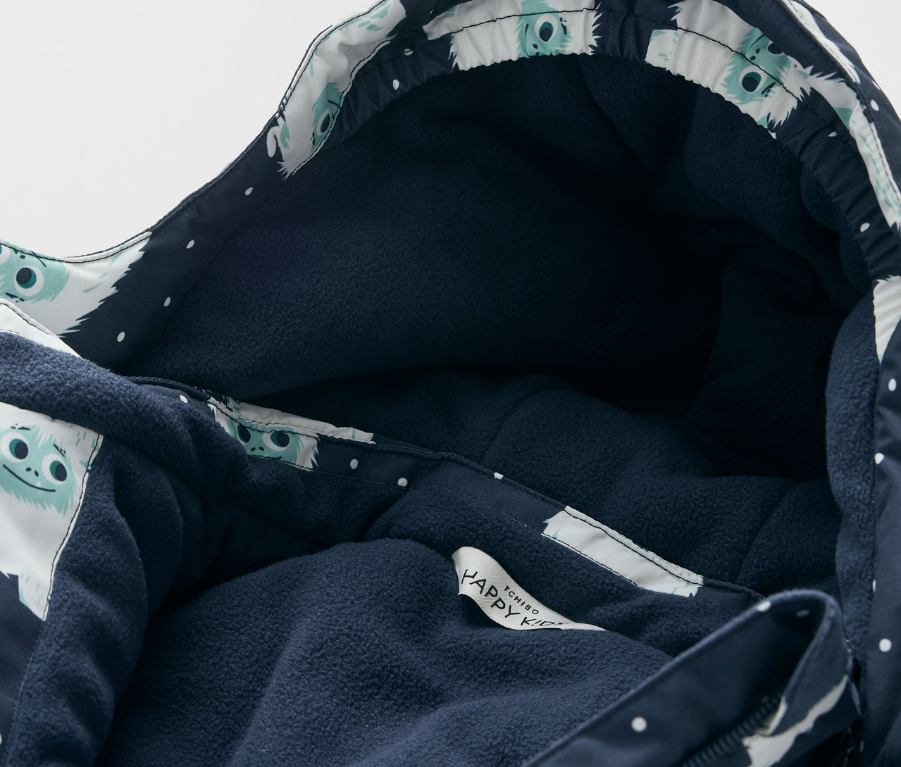 Detail bundy s kapucňou s tmavomodrou podšívkou a bielym vzorom postavičiek.