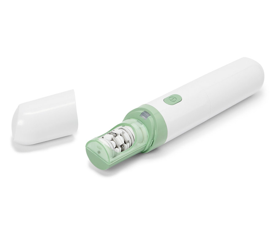 Biely elektronický pilník na nohy so zelenými akcentmi leží na bielom pozadí so zloženým ochranným krytom.
