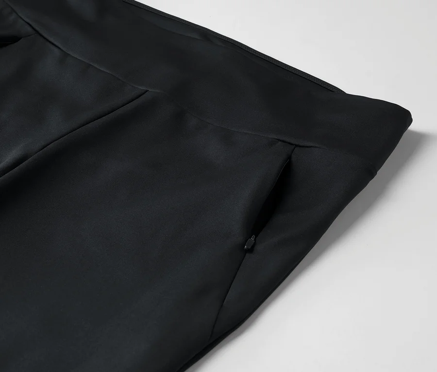 Detail čiernych nohavíc s vreckom na zips.