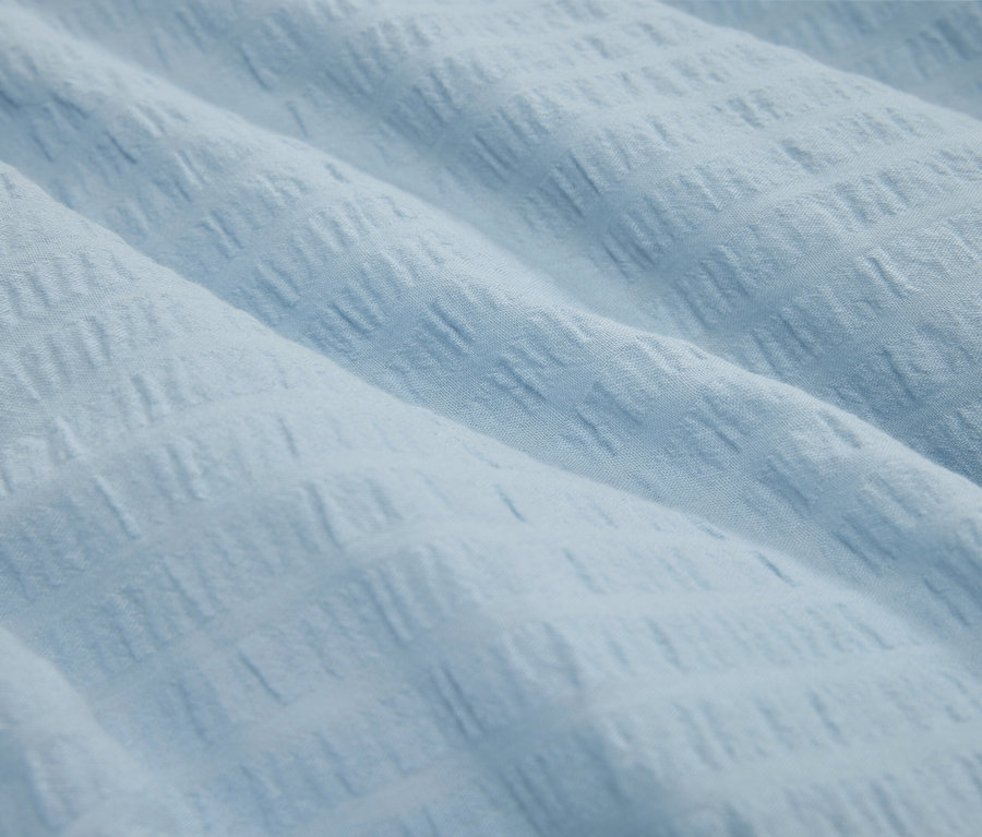 Detail svetlomodrej látky s textúrou.