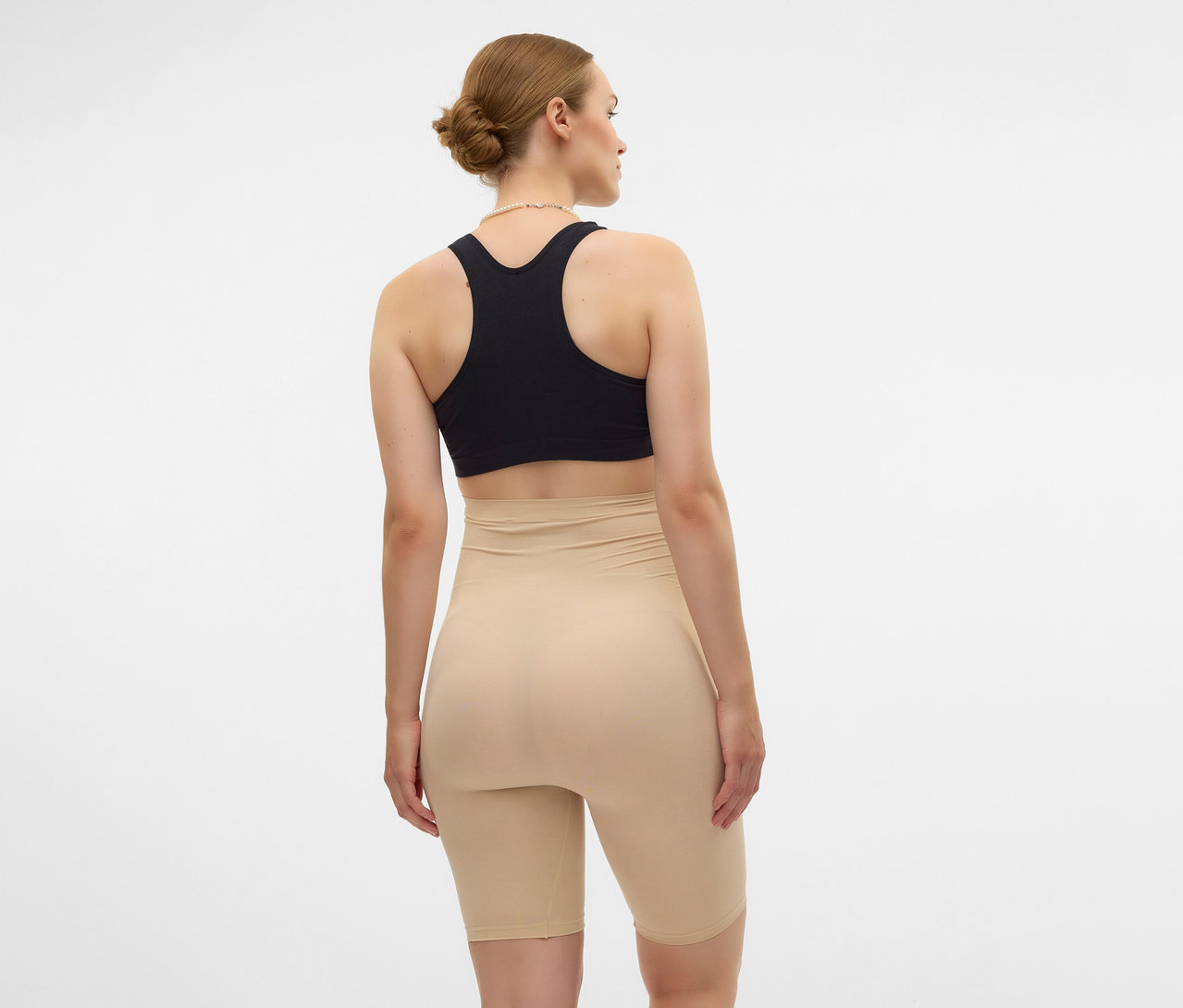 Žena zozadu v čiernej športovej podprsenke a čiernych skinny šortkách MAMALICIOUS »MLTIA JEANNE«.