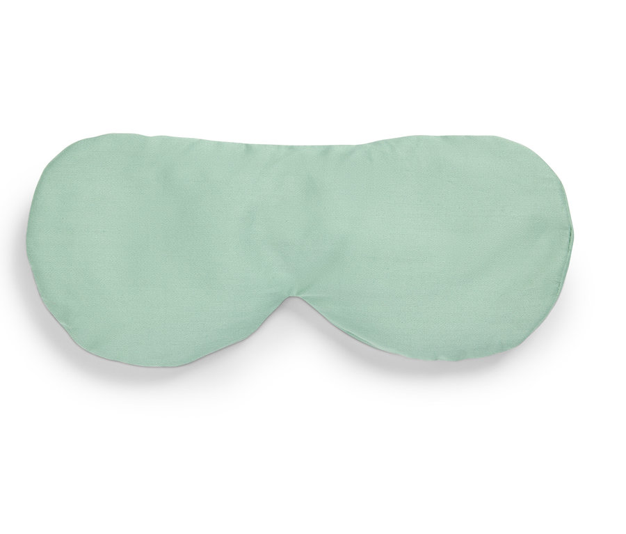 Svetlozelená maska na spanie leží na bielom pozadí.