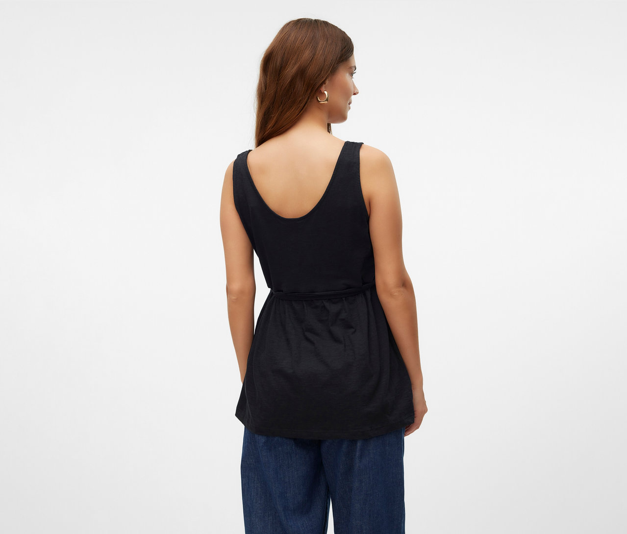 Žena zozadu v štýlovom tope MAMALICIOUS »MLEVI LIA« a modrých džínsoch.