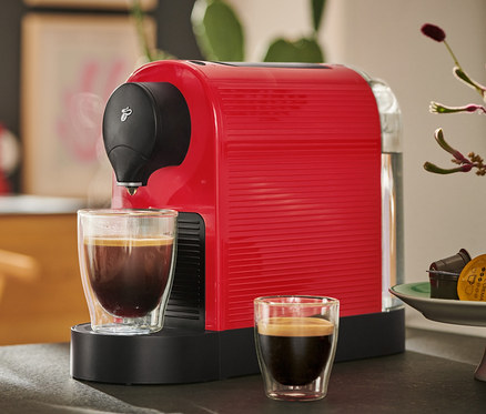 Červený kávovar Cafissimo pure+ s dvoma šálkami kávy.