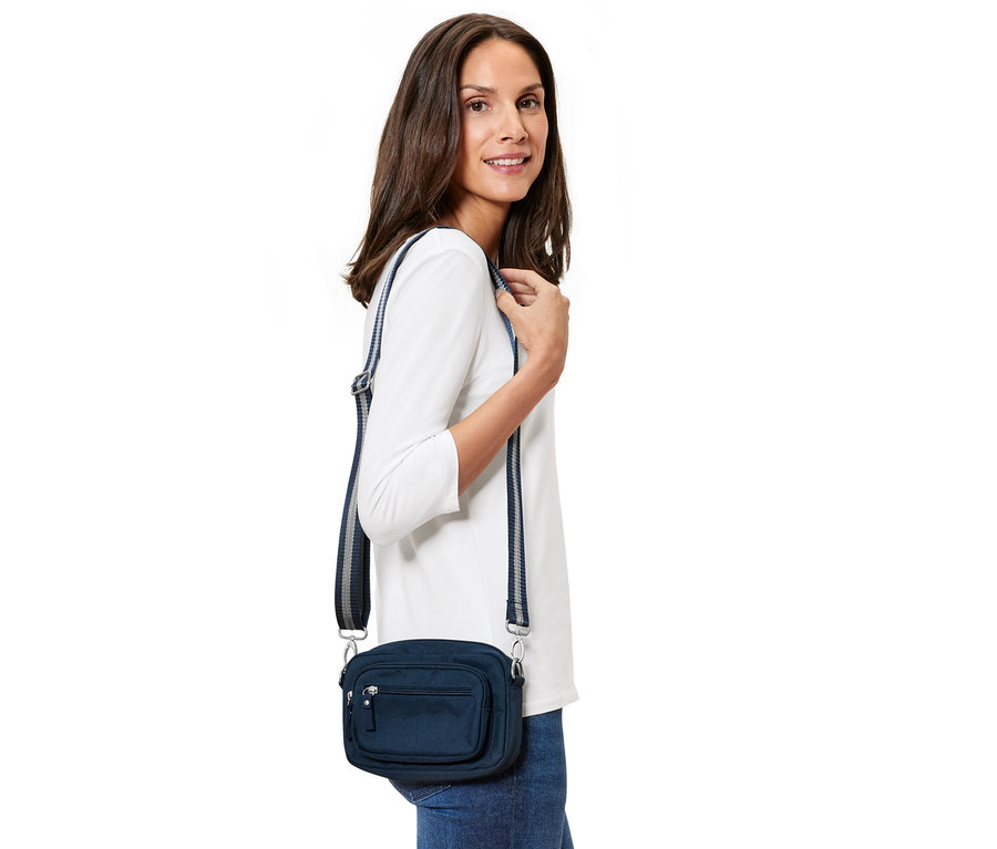 Žena pózuje s modrou bezpečnostnou taškou na rameno a ľadvinkou.