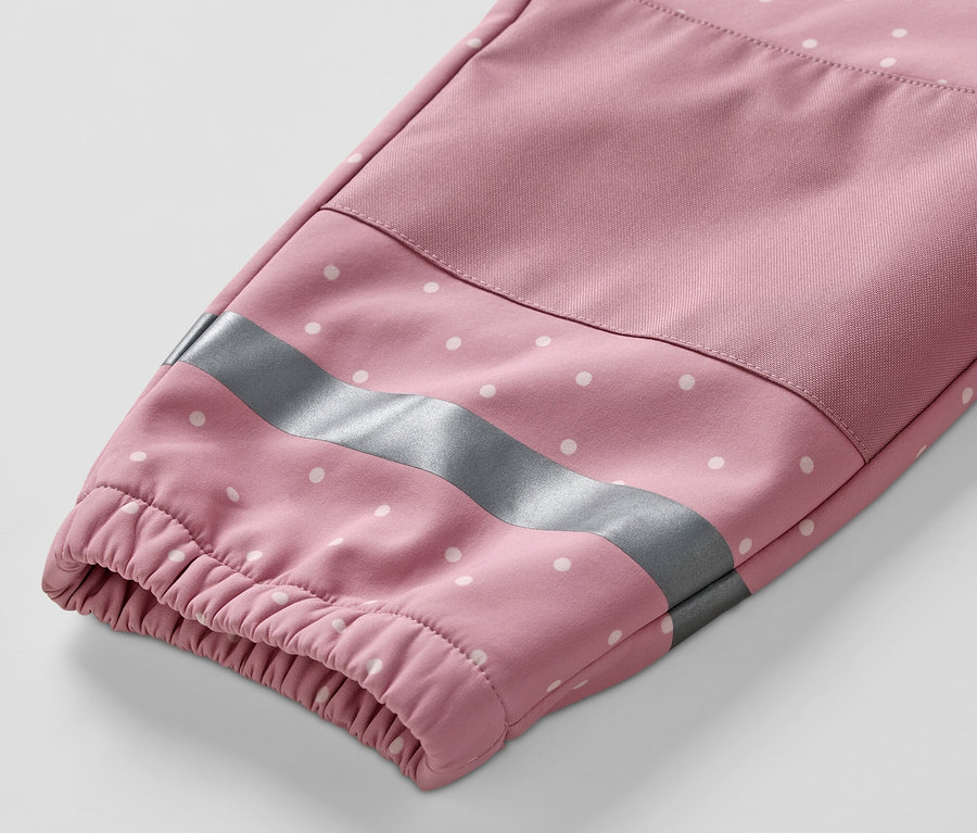 Detail rukávu detskej softshellovej kombinézy s bielymi bodkami a reflexným pruhom.