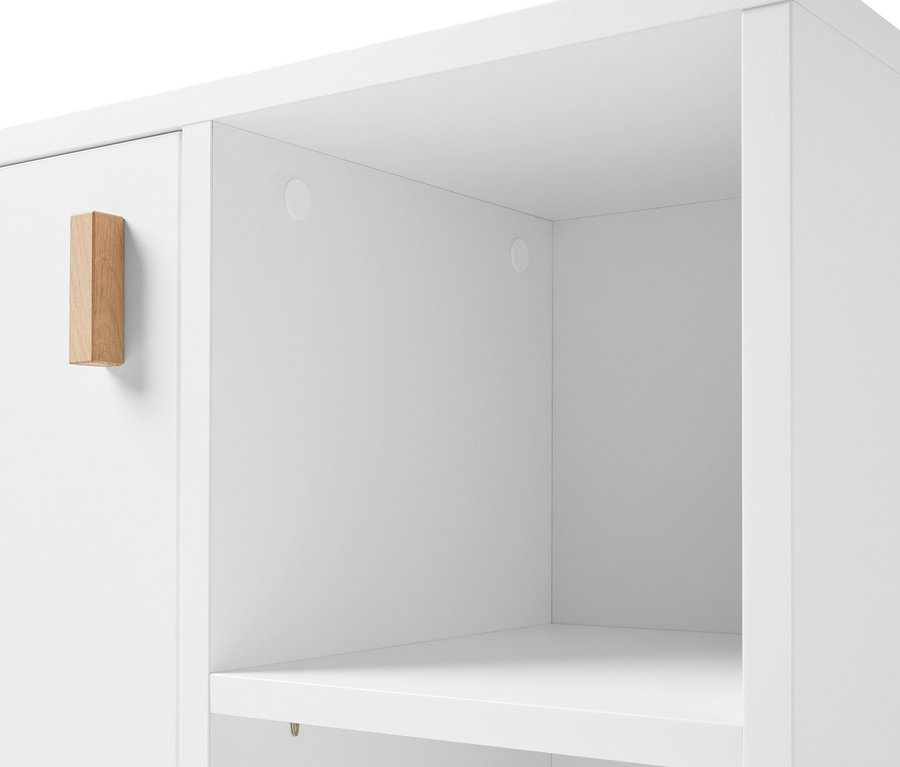 Detail bielej umývadlovej skrinky s dvierkami a poličkou naboku.