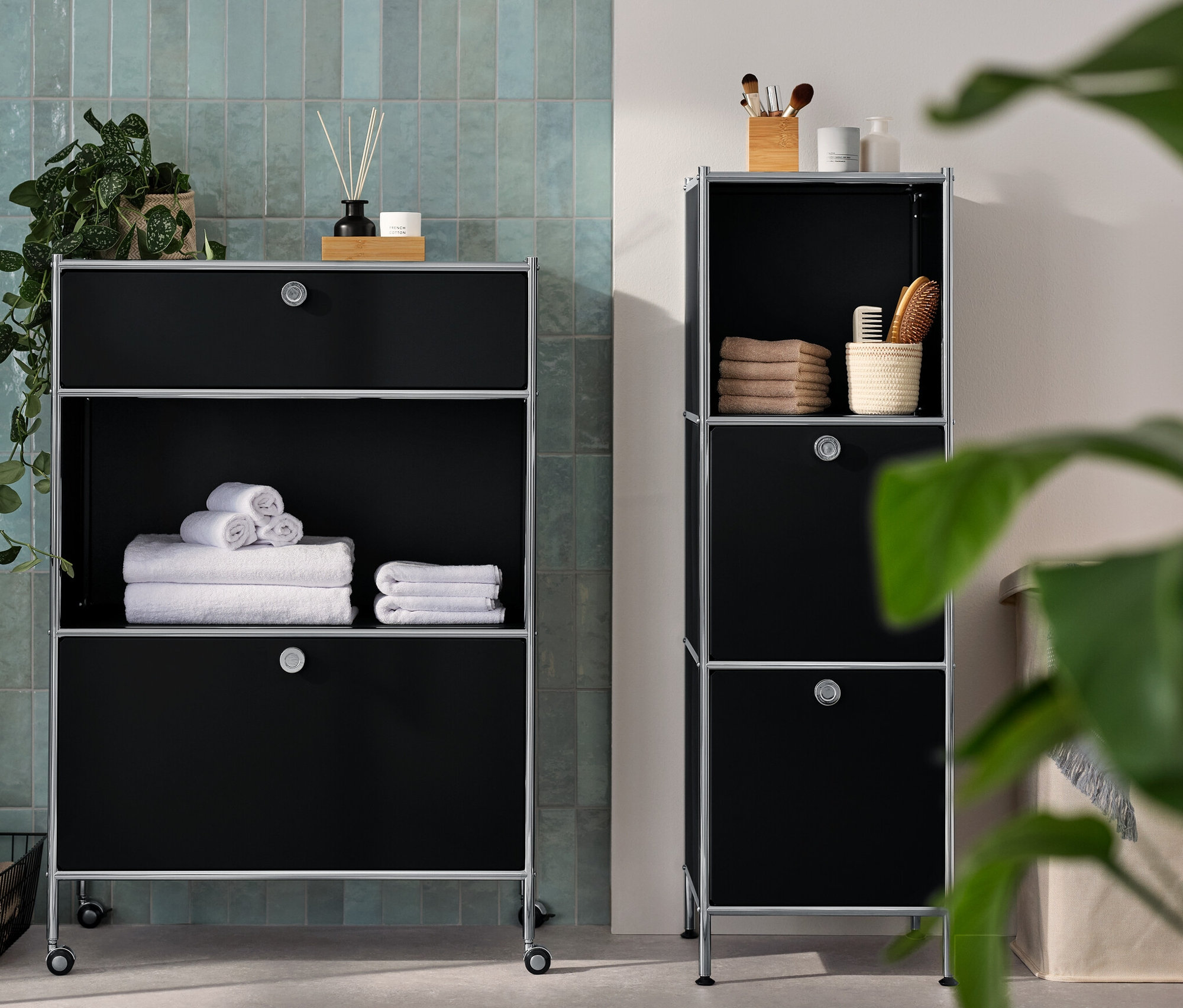 V kúpeľni je úzka kovová komoda »CN3« s
bsp2
výklopnými priečinkami a kovová komoda »CN3« s 1 zásuvkou a 1 výklopným priečinkom. Na komodách sú uteráky a doplnky.