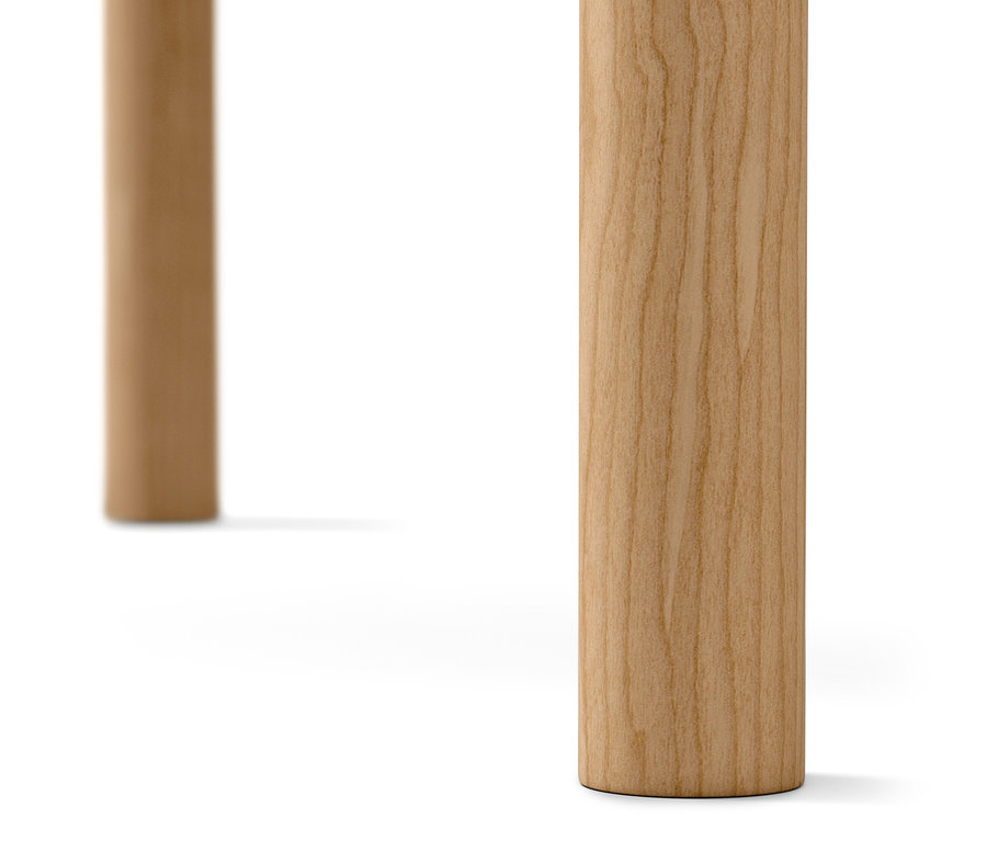 Detail dvoch svetlých drevených nôh stola na bielom pozadí.