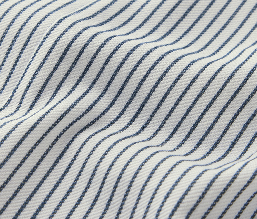 Detail detských tkaných nohavíc na traky s modrými prúžkami na bielom pozadí.