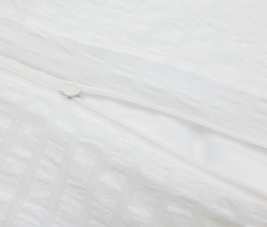 Detail bielej obliečky na paplón so zipsom.