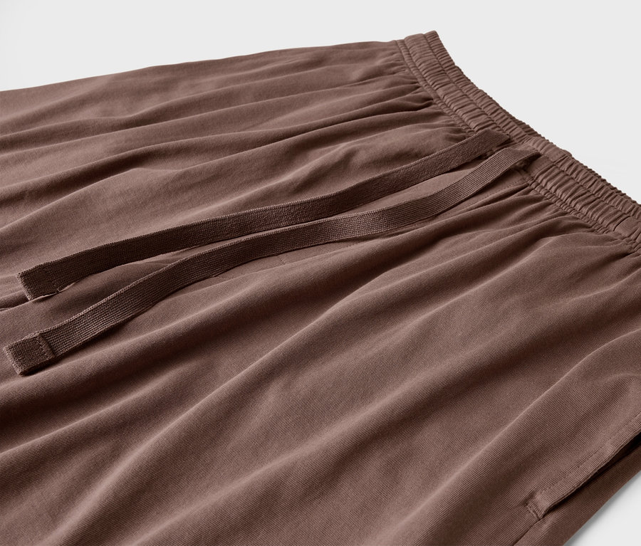 Detailný záber na hnedé nohavice so šnúrkou a vreckami.