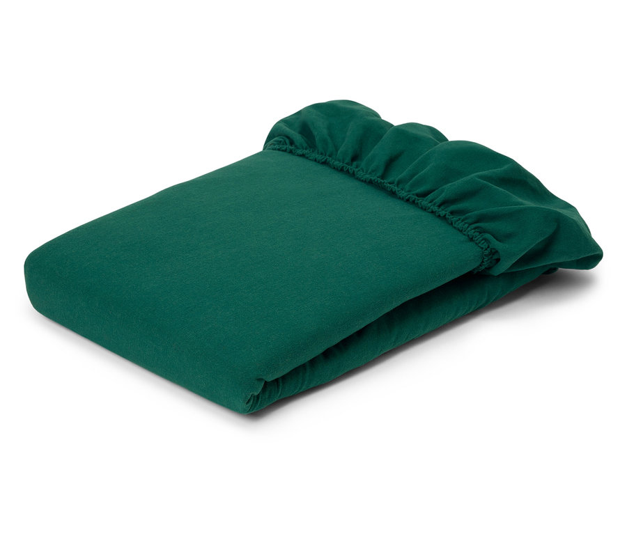 Zložené zelené prestieradlo s elastickými rohmi.