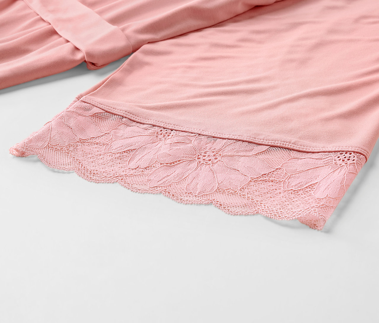 Detail ružového županu s čipkou.