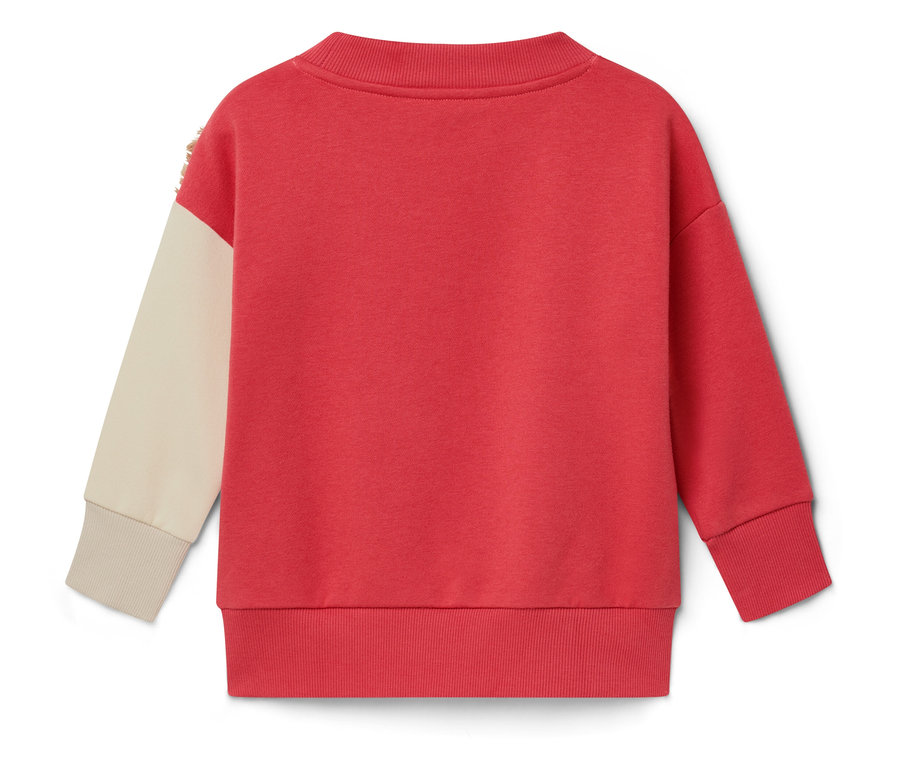 Pohľad zozadu na červenú mikinu s krémovým rukávom.