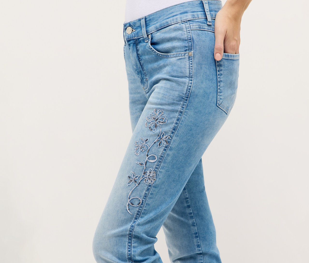 Osoba nosí džínsy Angels Denim »Cira Boho« s kvetinovou výšivkou a rukou vo vrecku.