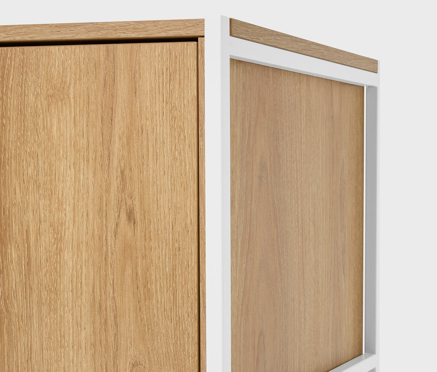 Detail dvoch svetlohnedých drevených skriniek s bielymi rámami.